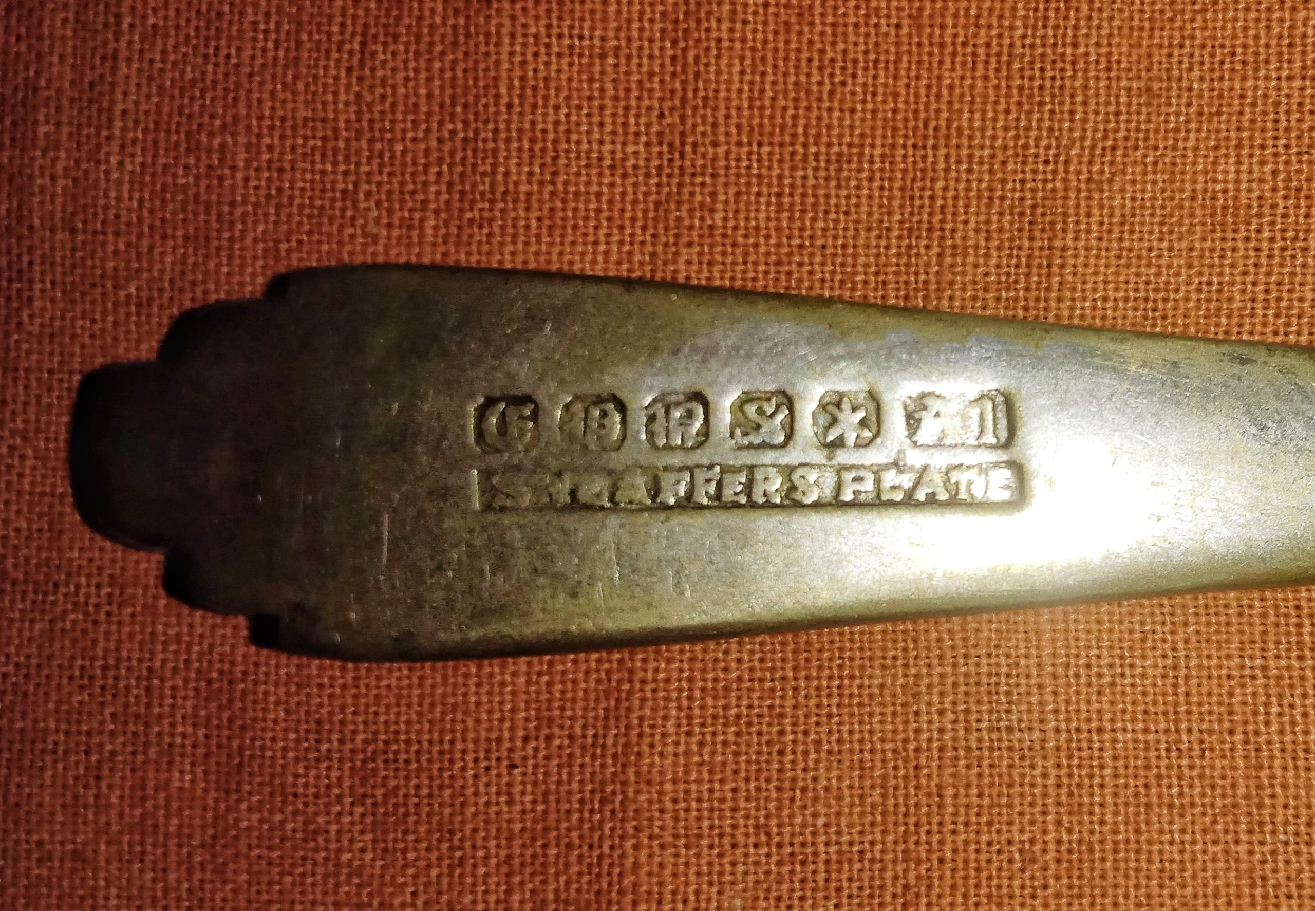 Examen des poinçons d'une pièce en argent ancienne avant un achat d'occasion